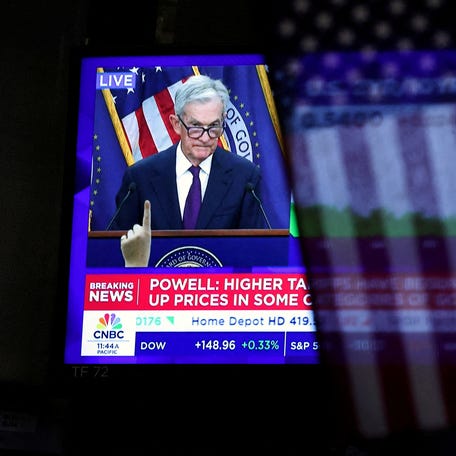 FILE PHOTO: A U.S. flag hangs in front of a screen that broadcasts a news conference by U.S. Federal Reserve Chair Jerome Powell following the Fed rate announcement, on the floor of the New York Stock Exchange (NYSE) in New York City, U.S., September 17, 2025. REUTERS/Brendan McDermid/File Photo