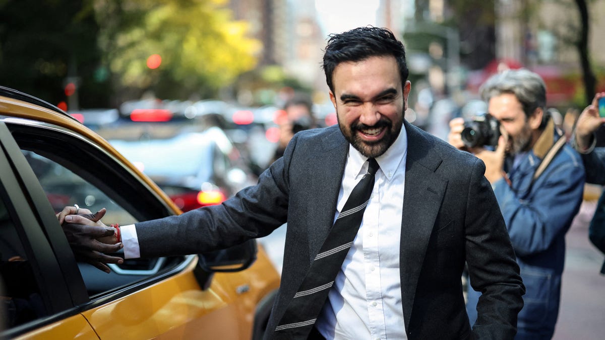 The Democratic nominee for New York City mayor, Zohran Mamdani, shakes the hand of a cab driver while campaigning in Manhattan's Upper East Side neighborhood during early voting on Oct. 27, 2025.