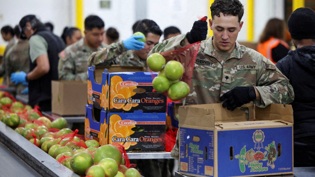 A member of the National Guard packs food at a Los Angeles Regional Food Bank facility, as nearly 42 million Americans face a potential lapse in Supplemental Nutrition Assistance Program (SNAP) benefits, known as food stamps, due to the second-longest U.S. government shutdown, in Los Angeles, California, U.S., October 29, 2025.