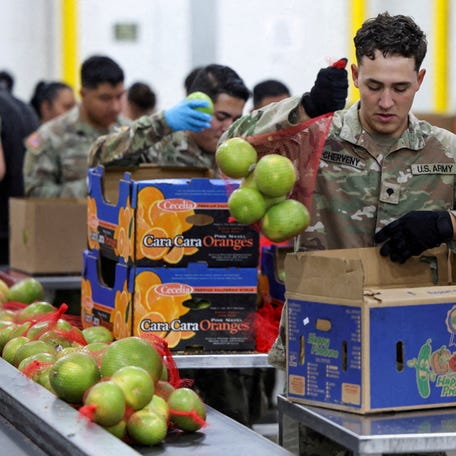 FILE PHOTO: A member of the National Guard packs food at a Los Angeles Regional Food Bank facility, as nearly 42 million Americans face a potential lapse in Supplemental Nutrition Assistance Program (SNAP) benefits, known as food stamps, due to the second-longest U.S. government shutdown, in Los Angeles, California, U.S., October 29, 2025. REUTERS/Daniel Cole/File Photo
