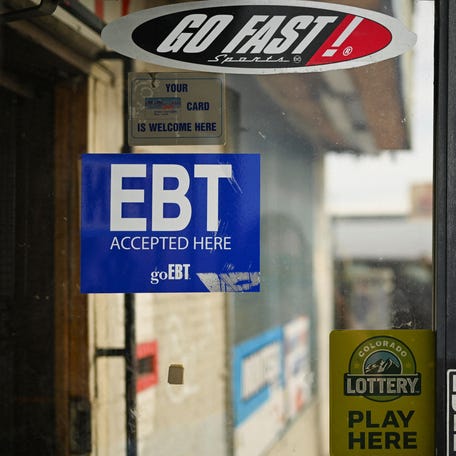A man runs past a convenience store featuring an affixed sticker that states 