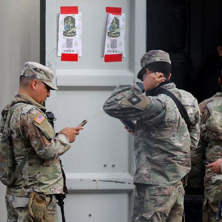 A member of the U.S. Army's 40th Infantry Division from California, and members of the 49th Military Police Brigade from California, part of the Army National Guard military police brigade, gather by a container with supplies at the Oregon Army National Guard's Camp Withycombe, as a divided U.S. appeals court ruled that U.S. President Donald Trump can send National Guard troops into Portland, in Happy Valley, Oregon, on Oct. 22, 2025.