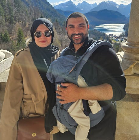 British commentator and analyst Sami Hamdi, carrying their child, and his wife, Soumaya T. Hamdi, in an undated family photo.