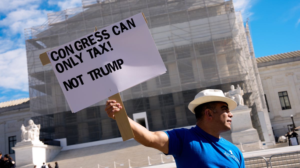 An activist holds a sign that reads "Congress Can Only Tax! Not Trump" outside the Supreme Court on Nov. 5, 2025 in Washington, DC.