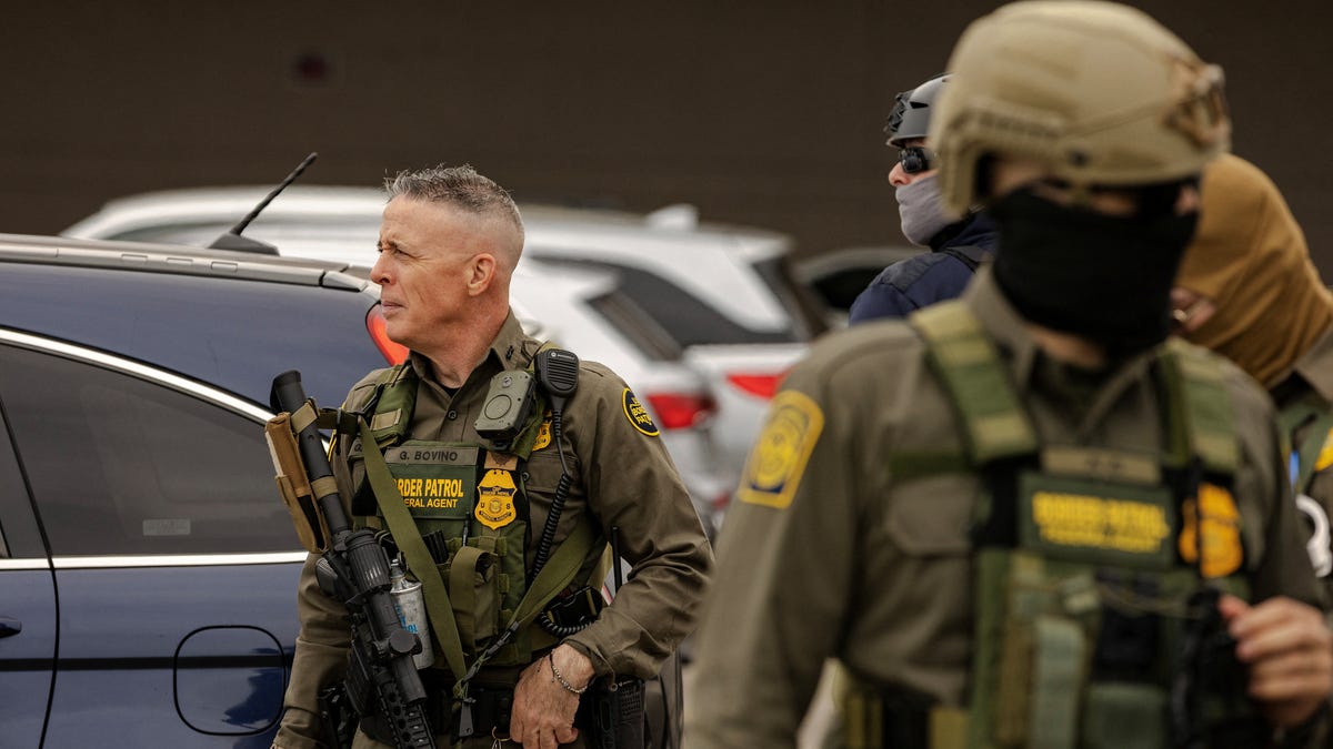 Border Patrol Chief Greg Bovino, the White House's top enforcer of President Donald Trump's Operation Midway Blitz crackdown on immigration enforcement in Chicago, stands with federal agents during an immigration raid.