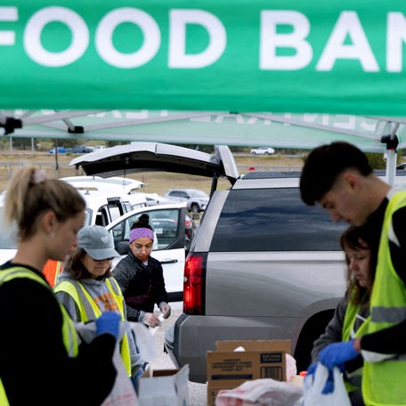 Volunteers place food items in vehicles during a mobile food distribution at Cedar Creek High School, as nearly 42 million Americans face a potential lapse in Supplemental Nutrition Assistance Program (SNAP) benefits, known as food stamps, due to the second-longest U.S. government shutdown, in Cedar Creek, Texas, U.S., November 1, 2025.