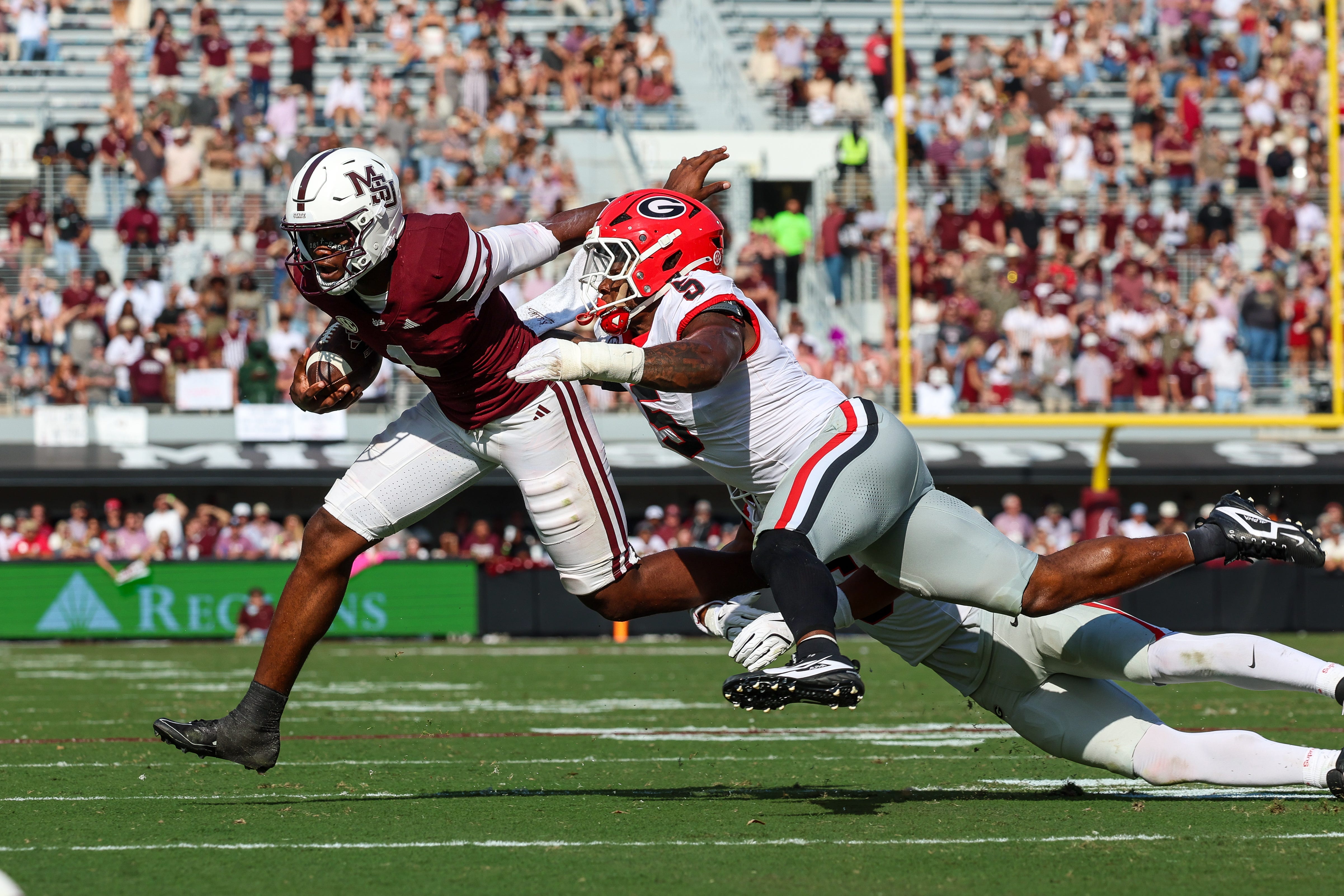 Nov 8, 2025; Starkville, Mississippi, USA; Mississippi State Bulldogs quarterback Kamario Taylor (1) runs with the ball against Georgia Bulldogs linebacker Raylen Wilson (5) during the second half at Davis Wade Stadium at Scott Field. Mandatory Credit: Wesley Hale-Imagn Images
