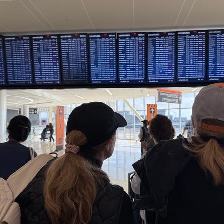People look at arrival and departures information at Hartsfield-Jackson Atlanta International Airport on Nov. 9, 2025. The government-mandated flight cancellations entered their third day on Nov. 9, leaving travelers once again glued to their phones and computers to see whether their flights are among the growing number of cuts.