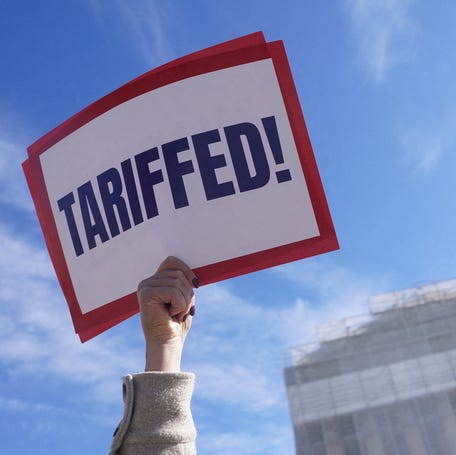 A protester outside the U.S. Supreme Court in Washington, DC, on Nov. 5, 2025, as justices are set to hear oral arguments on President Donald Trump's bid to preserve sweeping tariffs.