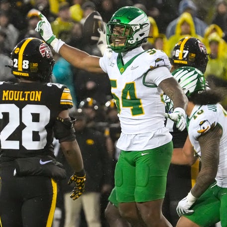 Oregon Ducks linebacker Jerry Mixon (54) singles first down for the Ducks after an Iowa Hawkeyes wide receiver Kaden Wetjen (21) fumble Nov. 8, 2025 during a Big Ten Football game at Kinnick Stadium in Iowa City, Iowa.