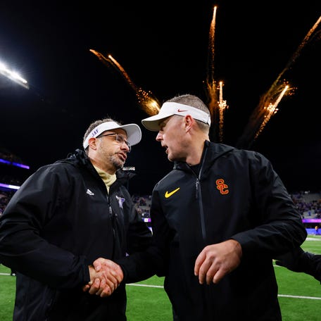 Nov 2, 2024; Seattle, Washington, USA; Washington Huskies head coach Jedd Fisch, left, shakes hands with USC Trojans head coach Lincoln Riley following a Washington victory at Alaska Airlines Field at Husky Stadium. Mandatory Credit: Joe Nicholson-Imagn Images