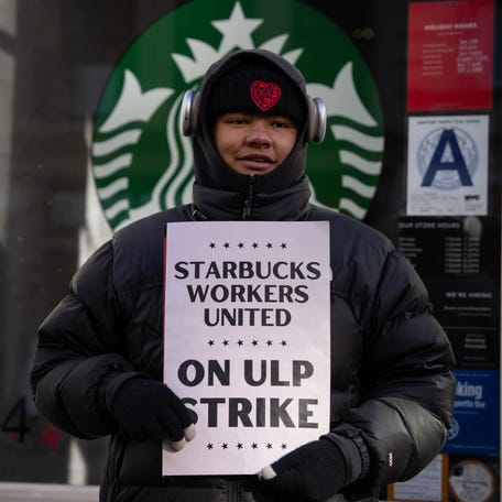 A Starbucks employee strikes outside of a closed Starbuck store on Dec. 23, 2024 in New York City.