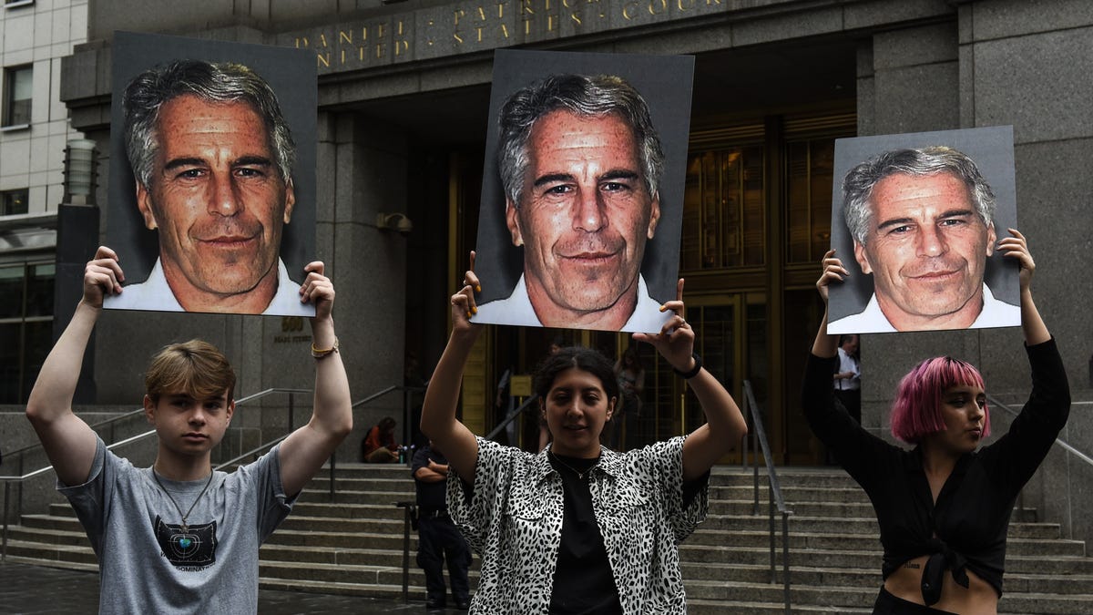 A protest group called "Hot Mess" hold up signs of Jeffrey Epstein in front of the Federal courthouse on July 8, 2019 in New York City.