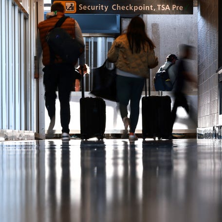 Travelers wait to pass a security checkpoint at Dulles International airport in Dulles, Virginia, U.S. November 13, 2025.