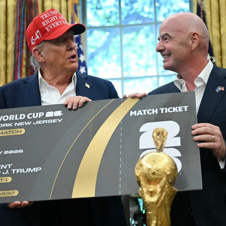 FIFA president Gianni Infantino (R) presents US President Donald Trump a FIFA world Cup ticket for the final match in the Oval Office of the White House in Washington, DC, on August 22, 2025. Trump announced the 2026 World Cup draw will be held on December 5 at Washington's Kennedy Center.