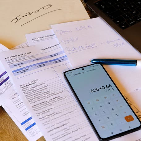 Illustration of a woman preparing her 2024 income tax return for the calculation of 2025 personal income tax on the tax administration website impot.gouv.fr in her living room in Valence, France, on April 9, 2025. (Photo by Nicolas Guyonnet / Hans Lucas / Hans Lucas via AFP) (Photo by NICOLAS GUYONNET/Hans Lucas/AFP via Getty Images)
