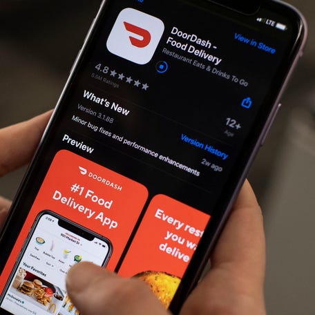 An AFP journalist checks the DoorDash food delivery application on her smartphone on February 27, 2020 in Washington, DC.