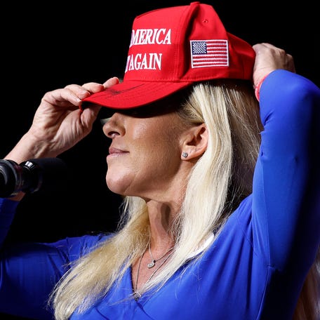 Rep. Marjorie Taylor Greene dons a Make America Great Again hat while addressing a campaign rally with Republican presidential nominee Donald Trump in 2024 in Rome, Georgia.