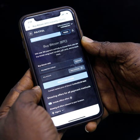 Abolaji Odunjo, a gadget vendor who trades with bitcoin, demonstrates a bitcoin application on his mobile phone after an interview with Reuters, at his store at the "Computer Village", in Lagos, Nigeria August 31, 2020. Picture taken in August 31, 2020. REUTERS/Temilade Adelaja