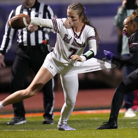 Red Mountain Mountain Lions receiver Ava Richardson (7) stretches for extra yards as her flag is pulled by Hamilton Huskies defender Harmony Cosby (4) during their 6A AIA Flag Football Championship game at Corona del Sol High School in Tempe, on Nov. 24, 2025.