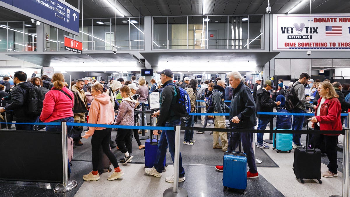 Travelers wait in line at a security checkpoint at O'Hare International Airport in Chicago, Illinois, on November 25, 2025, ahead of the upcoming Thanksgiving holiday.