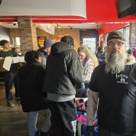 Victor Cruz, owner of Cruz Contracting, stands inside a busy Ziggy Bombs on Thanksgiving. Cruz was one of the main sponsors of a Thanksgiving event at Ziggy Bombs, providing free meals and clothing to the homeless.