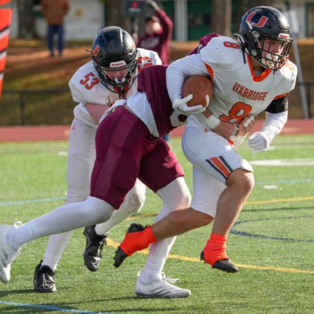 Uxbridge’s Camden LaChapelle drags Northbridge’s Bryce Rogozenski during their annual Thanksgiving game Nov. 27.