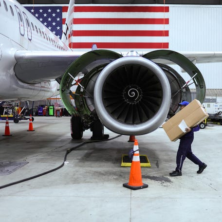 An employee of Jet Blue airlines walks around an engine of an Airbus A320 passenger aircraft in a maintenance hangar of the company at JFK International Airport in New York on March 4, 2024.