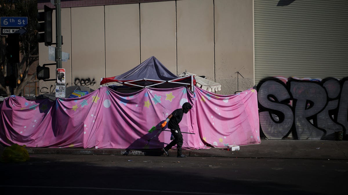 A man walks by a tent encampment in Skid Row, Los Angeles, California, U.S., December 9, 2024.