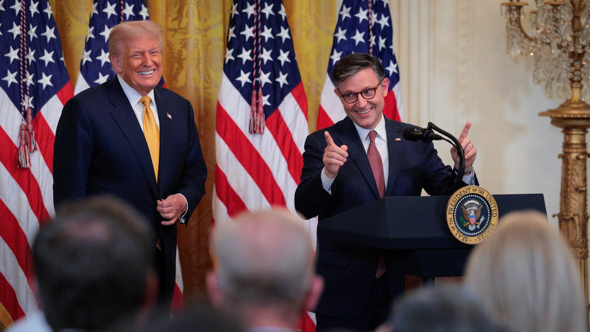 U.S. House Speaker Mike Johnson speaks as U.S. President Donald Trump looks on at a reception for Republican members of the House in the East Room of the White House on July 22, 2025 in Washington, DC. Trump thanked GOP lawmakers for passing the One Big Beautiful Bill Act.