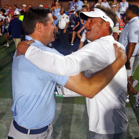 Sep 13, 2025; Oxford, Mississippi, USA; Mississippi Rebels head coach Lane Kiffin (right) reacts with Vice Chancellor for Intercollegiate Athletics Keith Carter (left) after defeating the Arkansas Razorback at Vaught-Hemingway Stadium. Mandatory Credit: Petre Thomas-Imagn Images