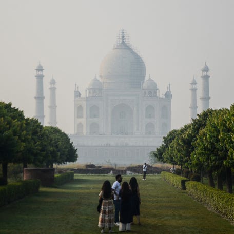 Tourists visit the Taj Mahal as thick smog engulfs the city skyline in Agra on October 21, 2025, a day after the Hindu festival of lights 'Diwali'.