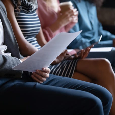 Close up of people sitting in line on sofa .
