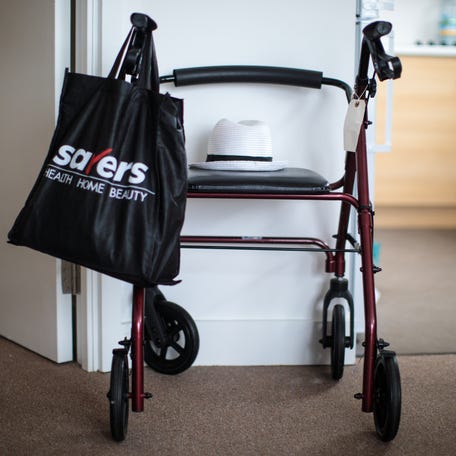 A rollator-style walker sits against a wall in senior living complex.