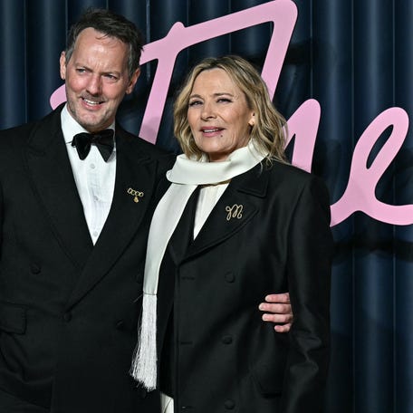 Kim Cattrall and Russell Thomas pose on the red carpet upon arrival at the 2025 Fashion Awards at the Royal Albert Hall in London on Dec. 1, 2025.