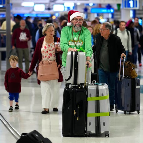 Christmas travelers make their way through the airport on Christmas Eve at Sky Habor Airport on Dec. 24, 2024, in Phoenix.