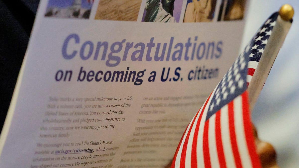 A new U.S. citizen holds an American flag after a naturalization ceremony in Boston on March 11, 2025.