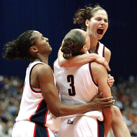 Sue Bird jumps into the arms of Diana Taurasi while Tamika Williams embraces the pair as UConn captures the 2002 national championship.