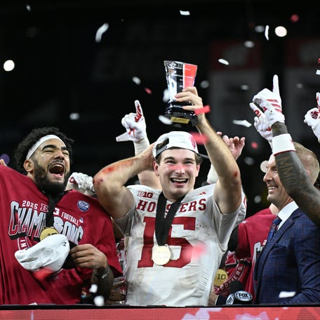 Indiana Hoosiers quarterback Fernando Mendoza (15) celebrates with the MVP trophy after defeating the Ohio State Buckeyes in the 2025 Big Ten championship game.