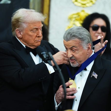 President Donald Trump presents Sylvester Stallone with a 2025 Kennedy Center Honorees medai in the Oval Office of the White House on Dec. 6, 2025 in Washington.