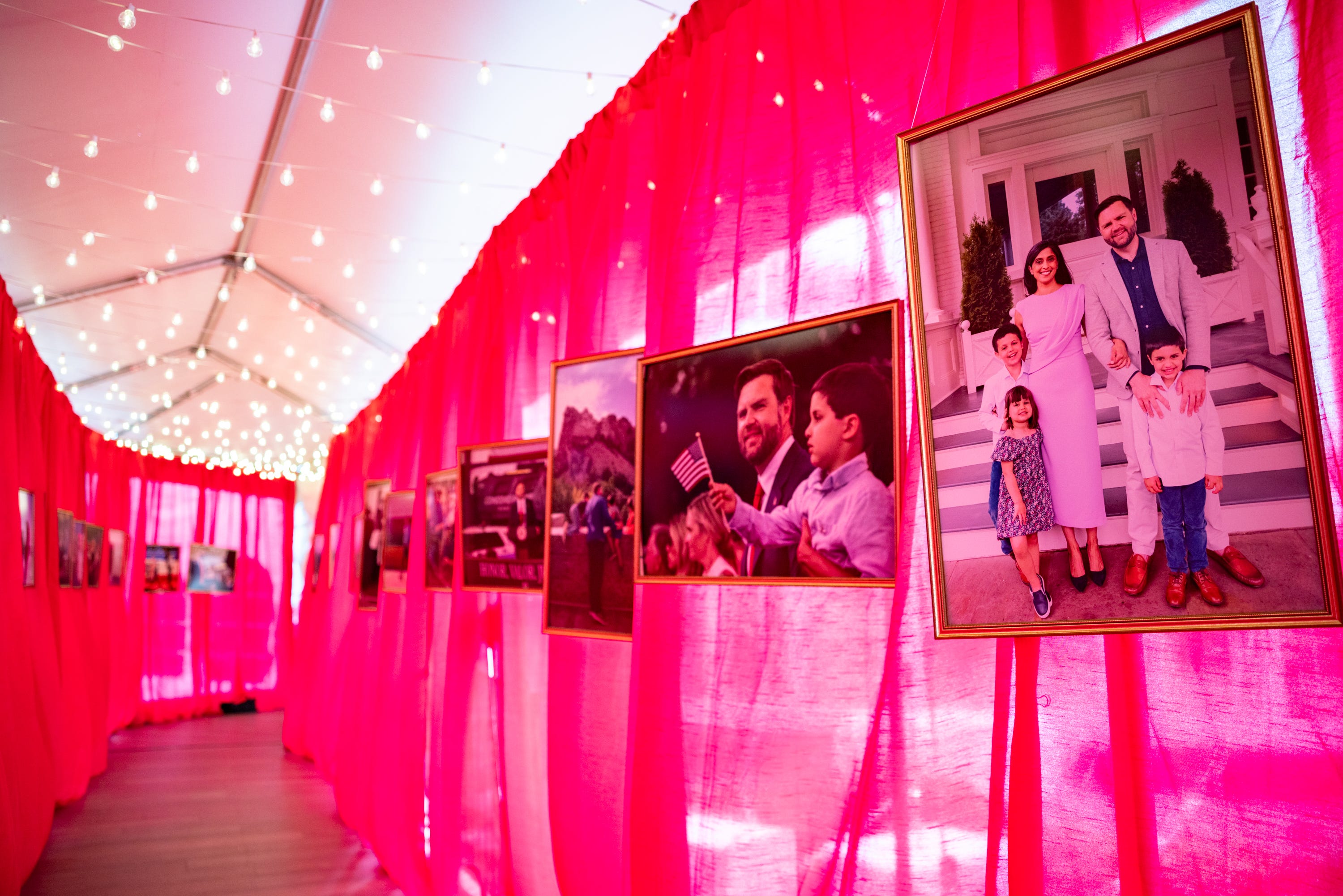<p style="margin: 0;">An exterior hallway of photographs, including one of Usha and JD Vance with their children, stretches between a celebratory tent and the vice president’s house on the grounds of the Naval Observatory on Dec. 8, 2025.</p>