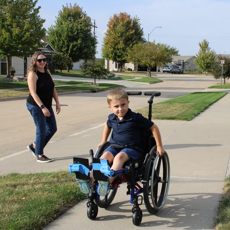 Isaac Schreier of Ankeny, Iowa, shows how he uses his specialized wheelchair to get around when he has broken bones from a condition called osteogenesis imperfecta. His parents, Maria and Jake Schreier, received legal assistance from the nonprofit group Disability Rights Iowa after the private company managing Isaac's Medicaid benefits refused to pay for the wheelchair.
