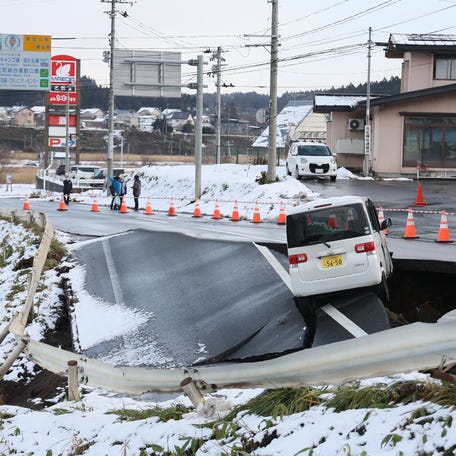 A vehicle rests on the edge of a collapsed road in Tohoku town in Aomori Prefecture on Dec. 9, 2025, following a 7.5 magnitude earthquake off northern Japan. The quake on Dec. 8 left at least 30 injured, authorities said, damaging roads and leaving thousands without power in freezing temperatures.