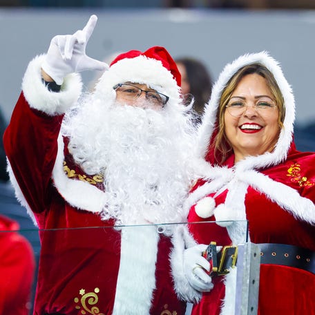 Fans dressed as Santa and Mrs. Claus attend the game between the BYU Cougars and Texas Tech Red Raiders at AT&T Stadium in Arlington, Texas on Dec. 6, 2025.