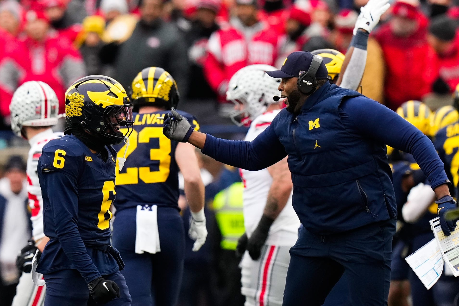 Michigan Wolverines head coach Sherrone Moore celebrates with defensive back Brandyn Hillman.