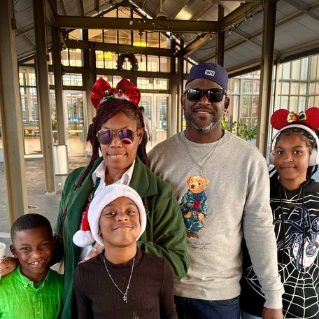 Chris and Shawnell Thiel stand with their kids outside the Riverwalk Outlets in New Orleans on Dec. 7, 2025, after watching the city's Christmas parade and doing a little holiday shopping.