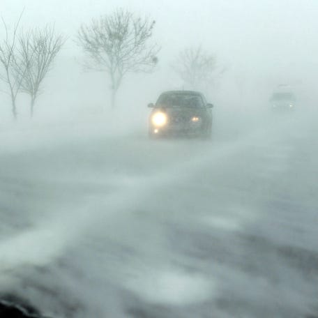 Cars drive on a road during a snowstorm near Bucharest January 29, 2014. REUTERS/Bogdan Cristel (ROMANIA - Tags: ENVIRONMENT TRANSPORT TPX IMAGES OF THE DAY)