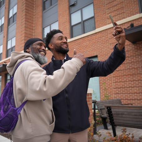 Baltimore Mayor Brandon Scott takes a photo passerby near The Terraces at Park Heights.