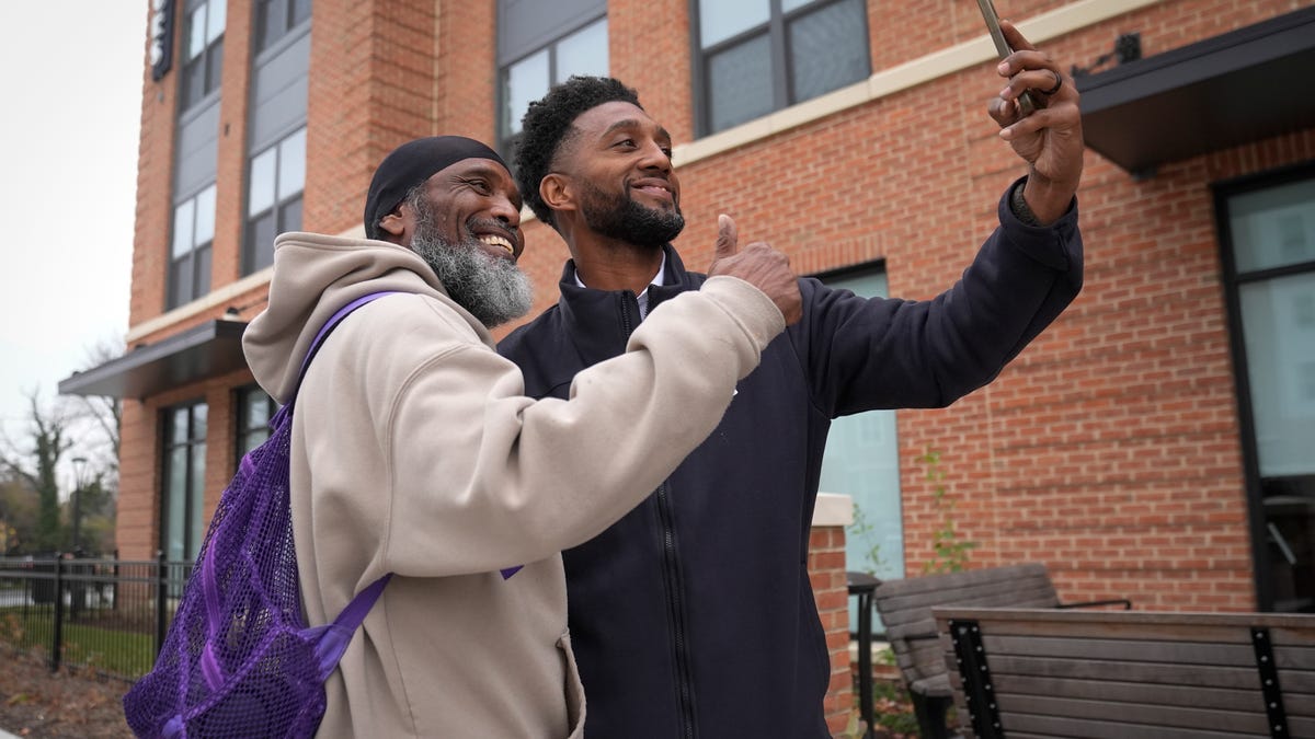 Baltimore Mayor Brandon Scott takes a photo passerby near The Terraces at Park Heights.