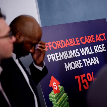 Lester Johnson (L), a restaurant owner in Richmond, Virginia, stands next to a sign that reads "Affordable Care Act Premiums Will Rise More Than 75%" during a news conference to call on Republicans to pass Affordable Care Act tax breaks on Capitol Hill on September 16, 2025 in Washington, DC. Democratic Senators joined Protect Our Care and advocates to call on the GOP to protect health care for Americans and stop premium hikes.
